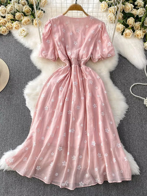 Dusty pink embroidered puff sleeve midi dress with elastic waist and floral pattern.