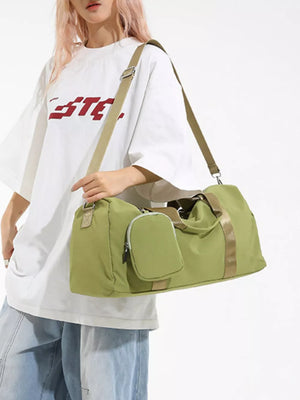 Green duffle bag with detachable pouch and tan strap.