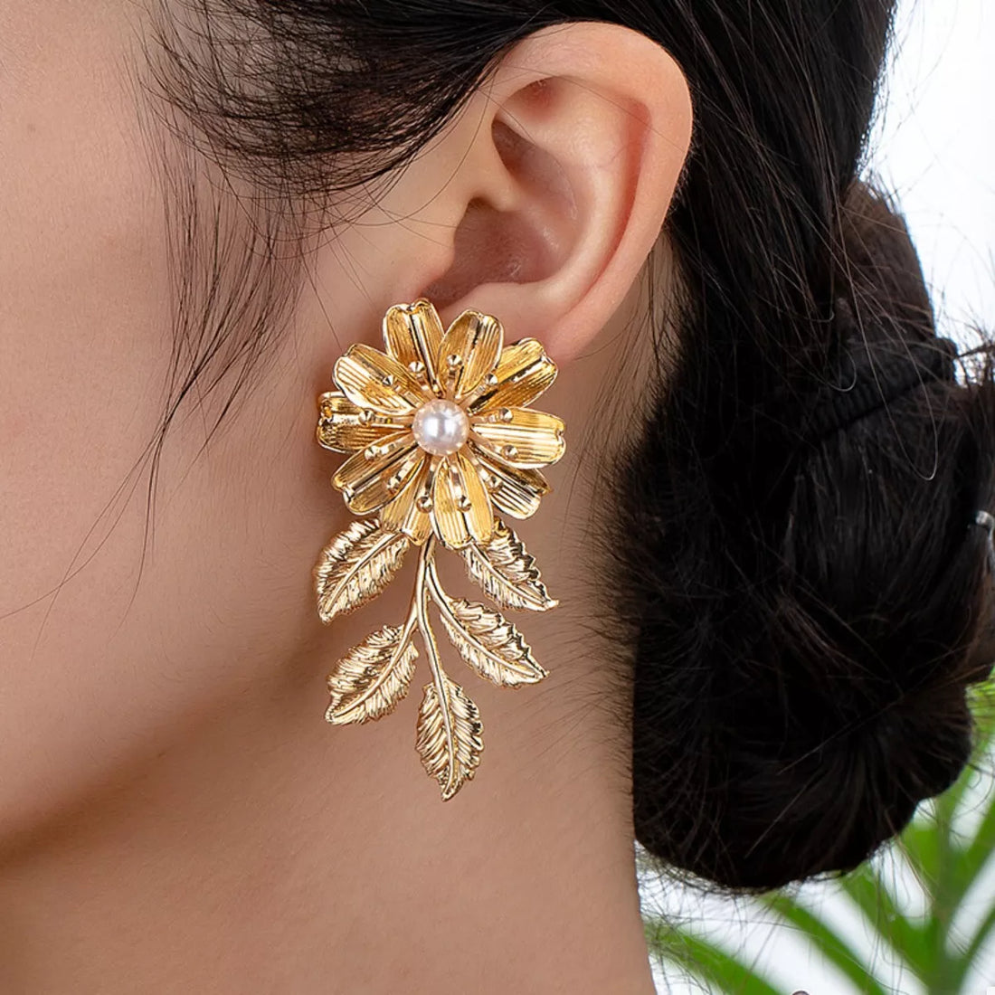 Golden 18K gold-plated floral drop earrings with pearl accent and leaf details.