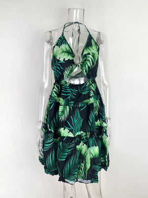 Halter mini dress with tropical leaf print, cutout detail, and tiered skirt.