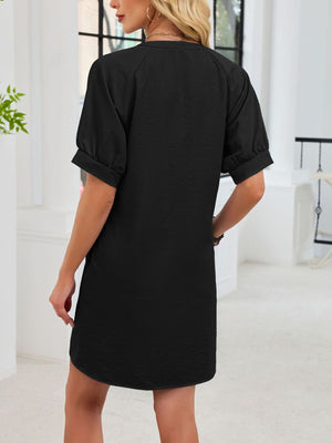Black cotton dress with short puff sleeves and a textured finish.