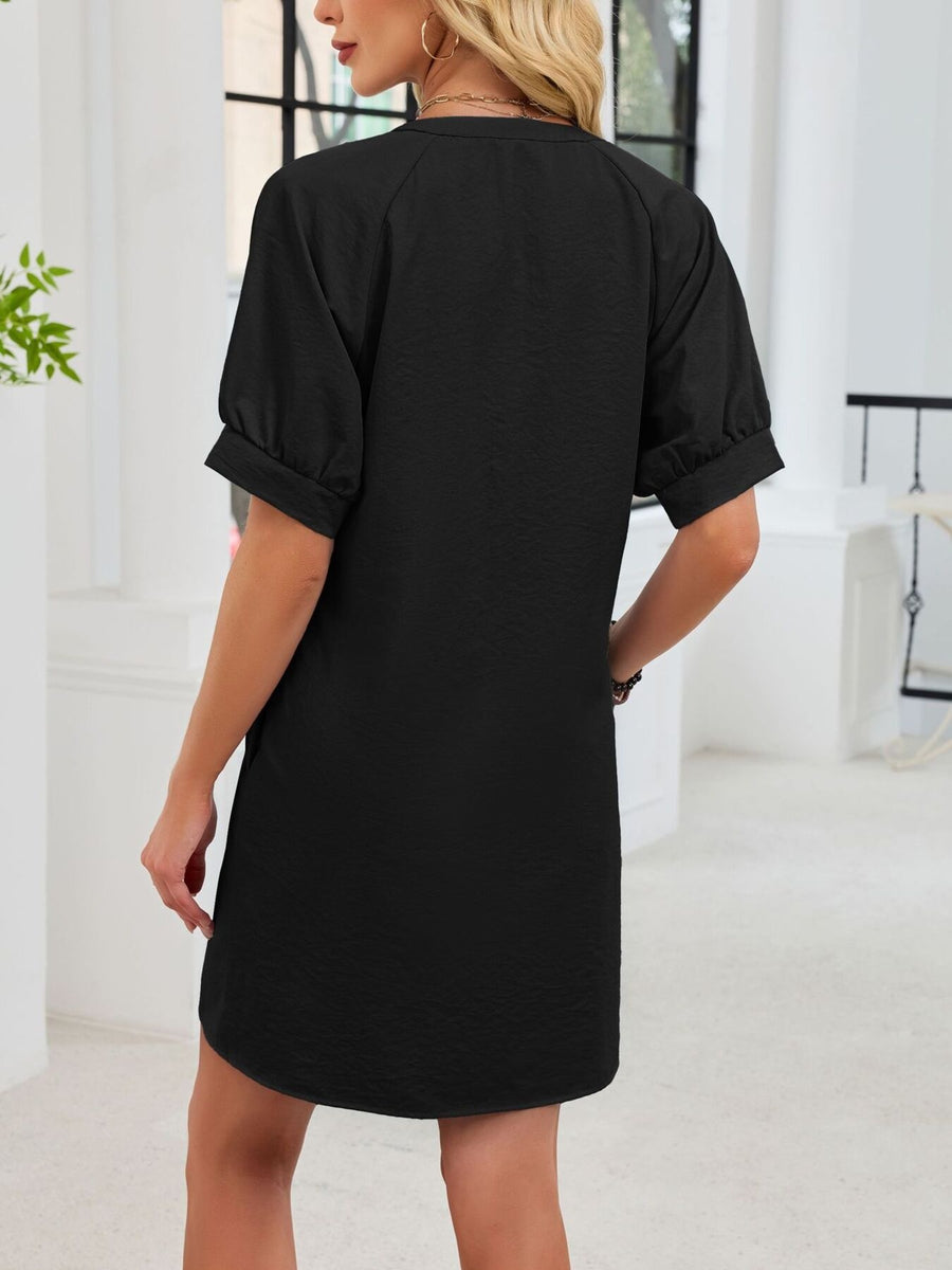 Black cotton dress with short puff sleeves and a textured finish.
