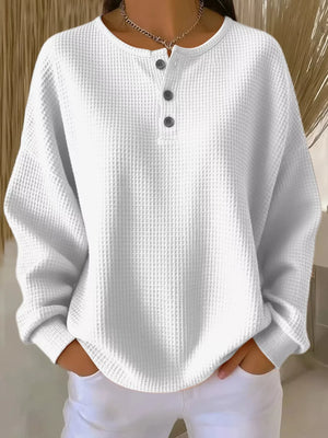 White waffle knit button detail top with crew neck and long sleeves.