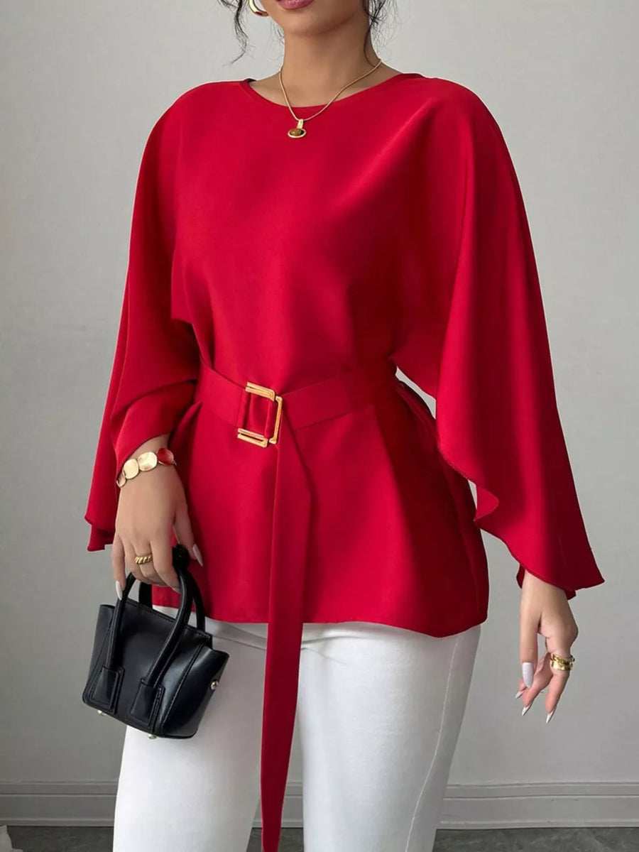 Red belted blouse with batwing sleeves and gold buckle detail.