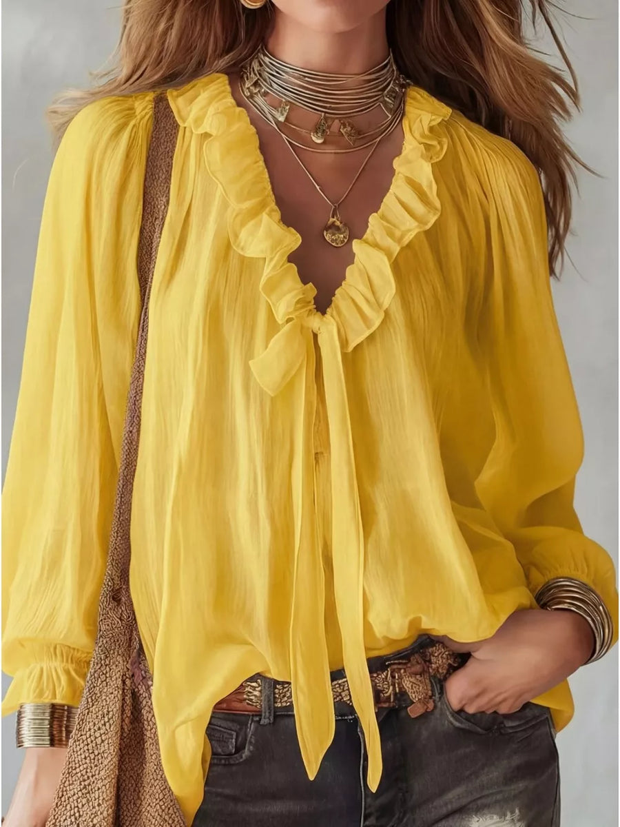 Yellow frilled tie-front shirt with ruffled neckline and long sleeves.