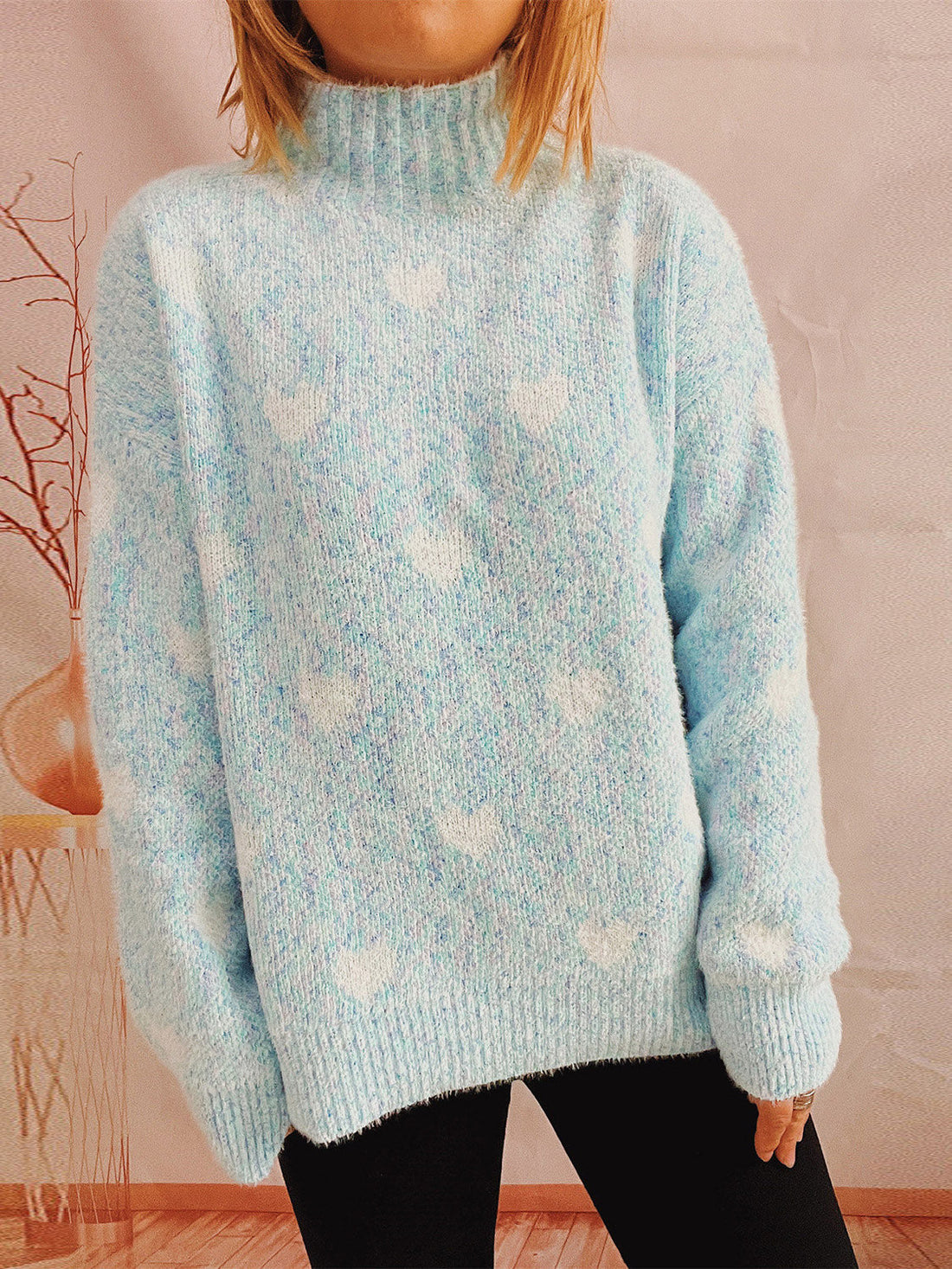 Mint blue acrylic turtleneck sweater with white heart pattern and textured knit.