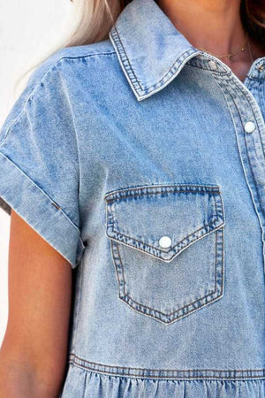 Light blue denim shirtdress with short sleeves, button-down front, chest pocket, and tiered ruffled hem.