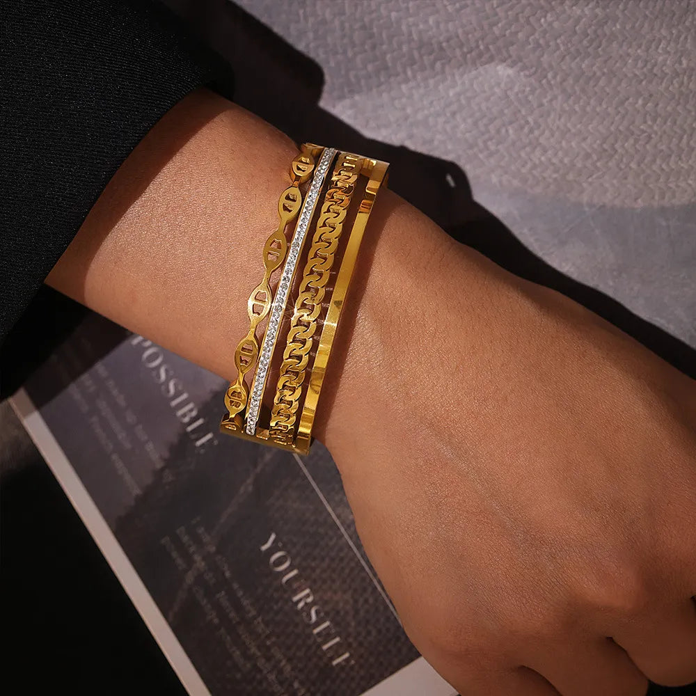 Gold cuff bracelet set with chain and crystal details