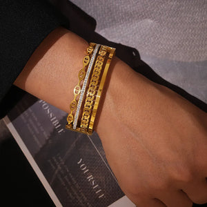 Gold cuff bracelet set with chain and crystal details