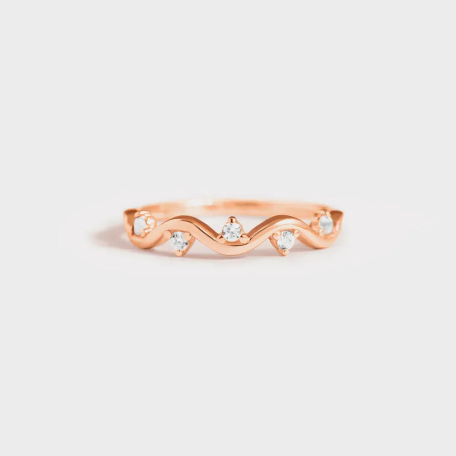 Rose gold band ring with wavy design and small clear stones