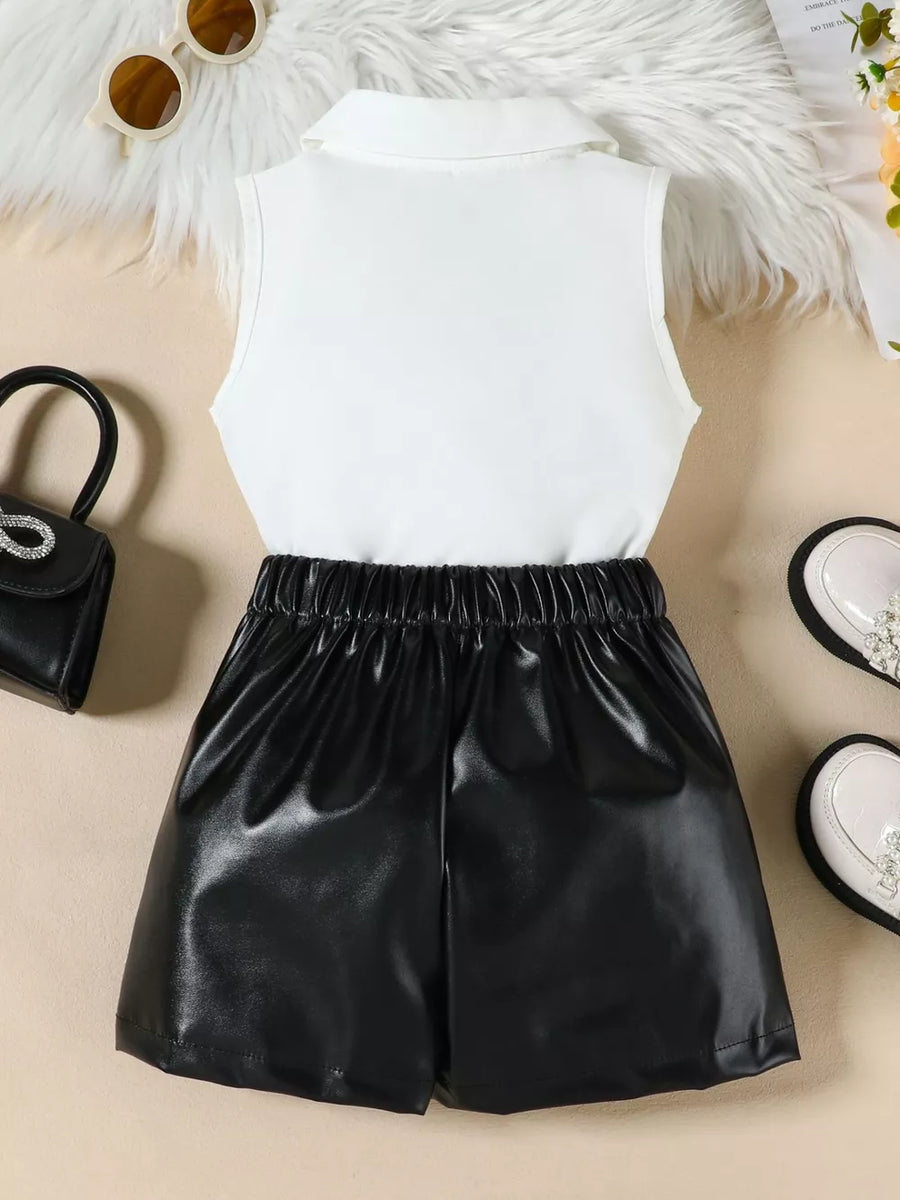 Girls' black faux leather skort with elastic waist and white collared sleeveless top.