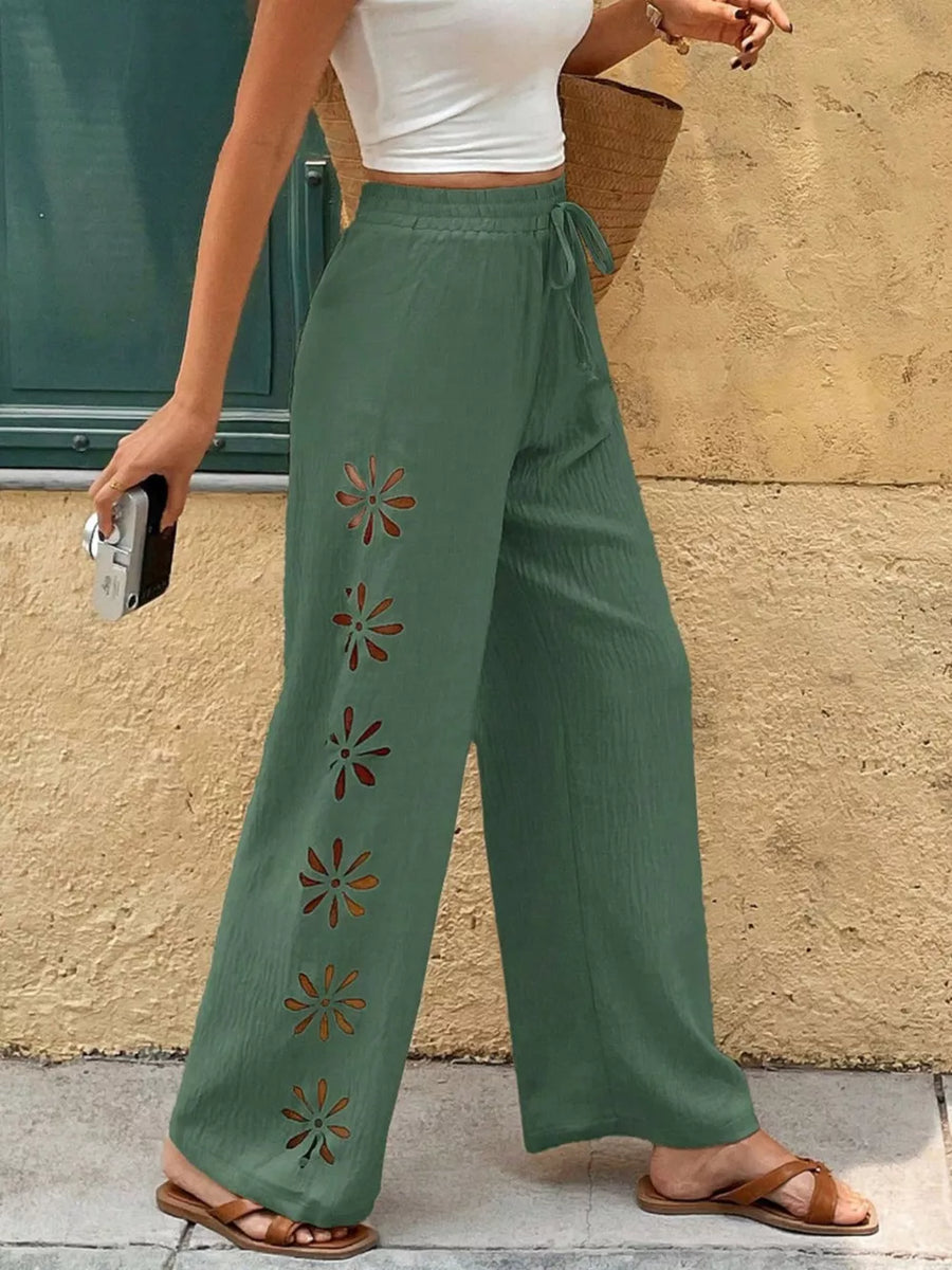 Green wide-leg pants with floral cutouts and drawstring waist