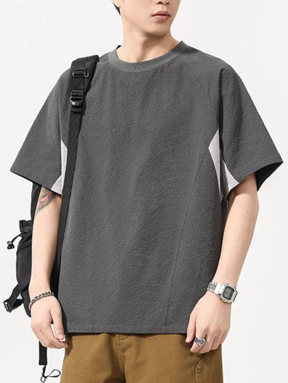 Men's dark gray textured t-shirt with contrast panels and crew neck.