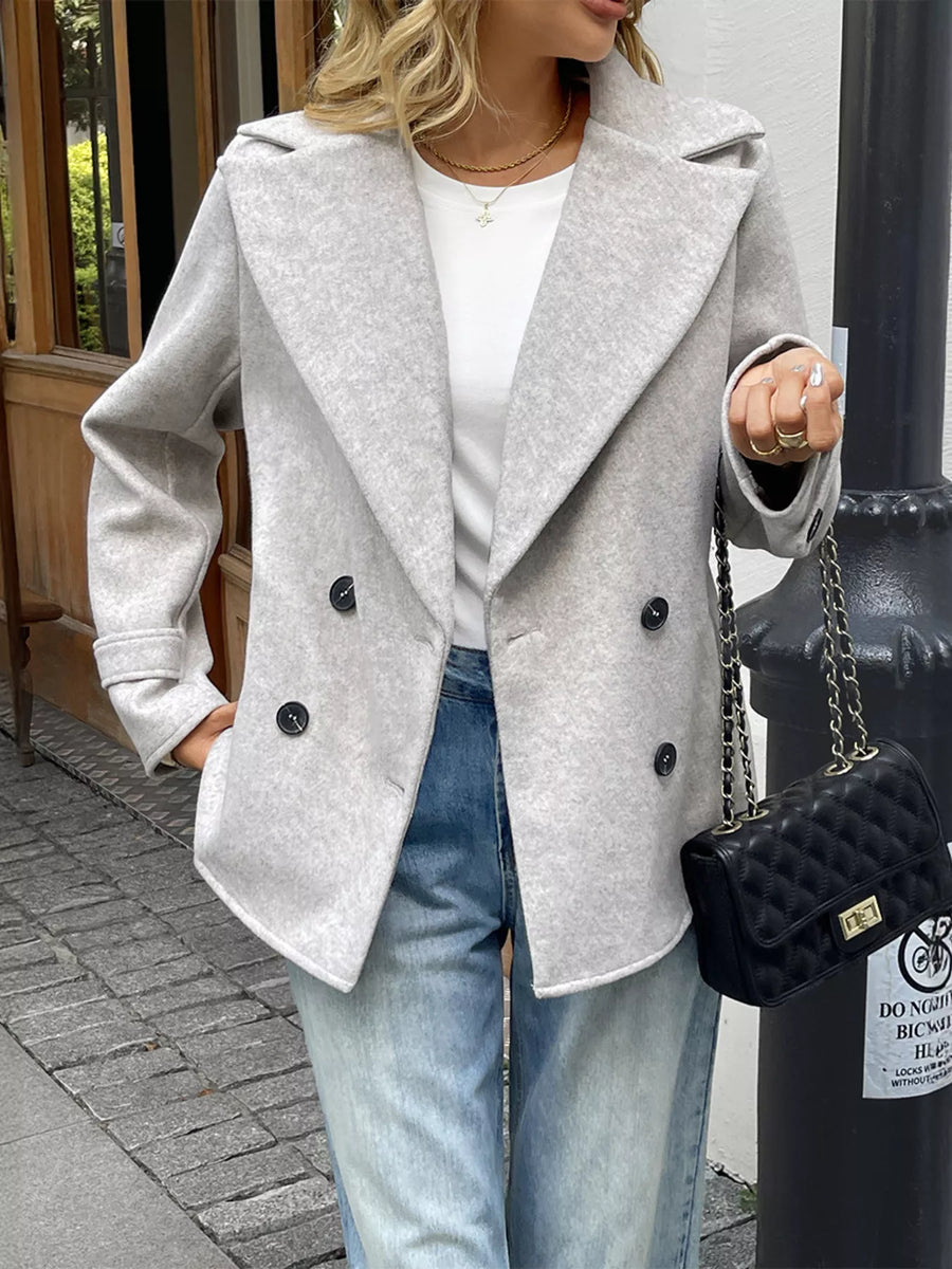 Light grey wool blend double-breasted overcoat with a notched lapel and button closure.