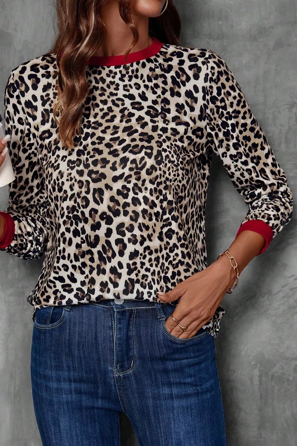 Leopard print long-sleeve blouse with red trim at the neckline and cuffs.