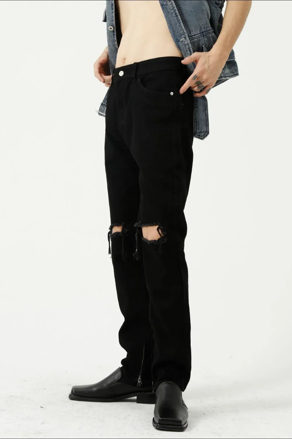 Black denim jeans with distressed knees and a modern straight leg cut.