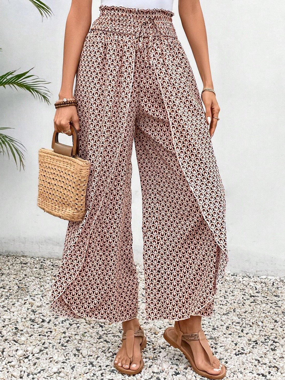Palazzo pants in blush pink with a geometric print and wrap-front detail.