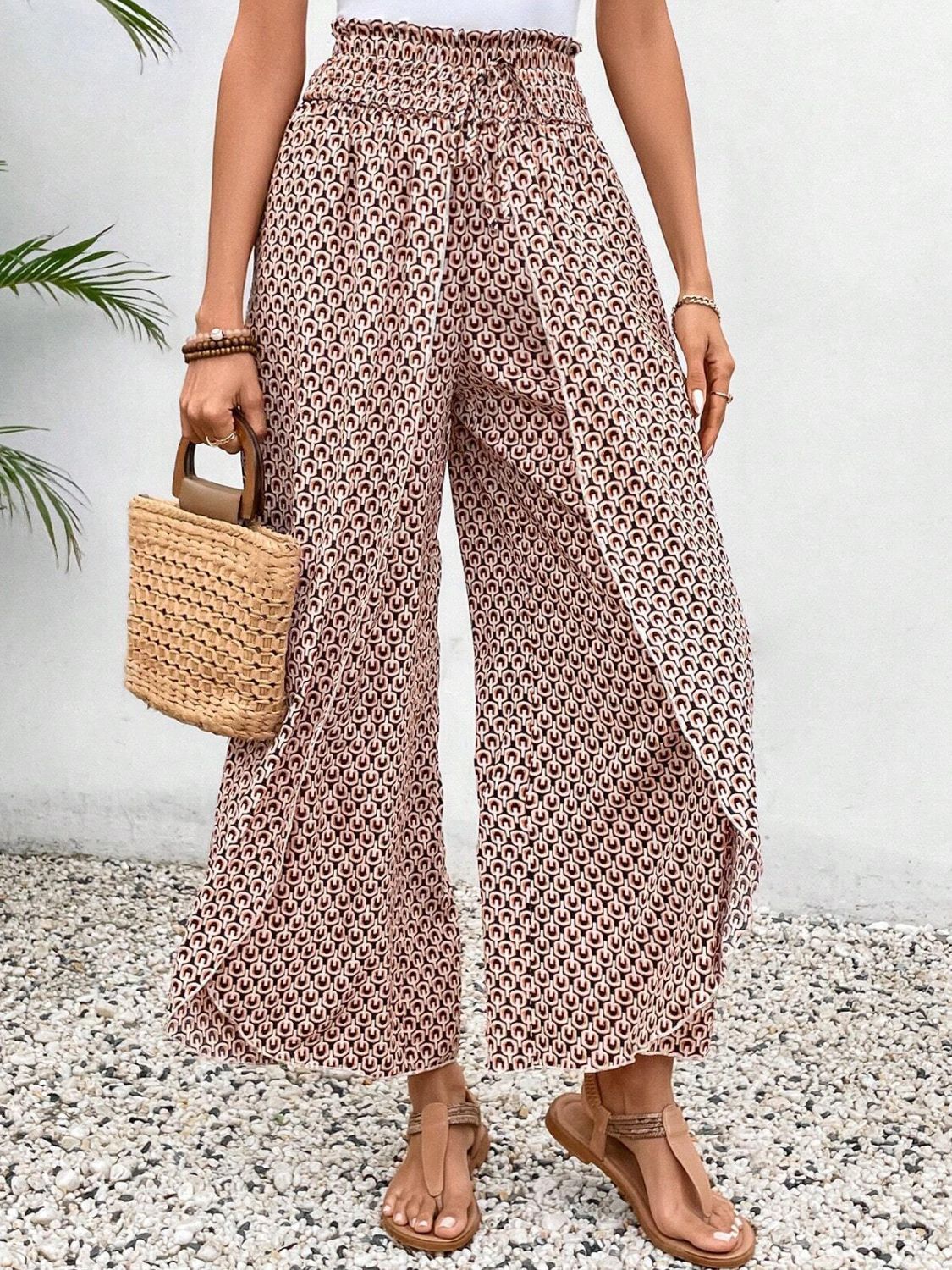 Palazzo pants in blush pink with a geometric print and wrap-front detail.