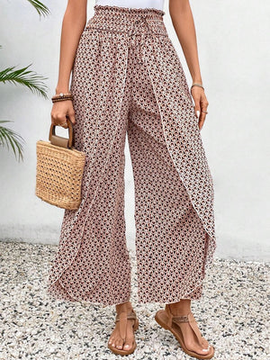 Palazzo pants in blush pink with a geometric print and wrap-front detail.
