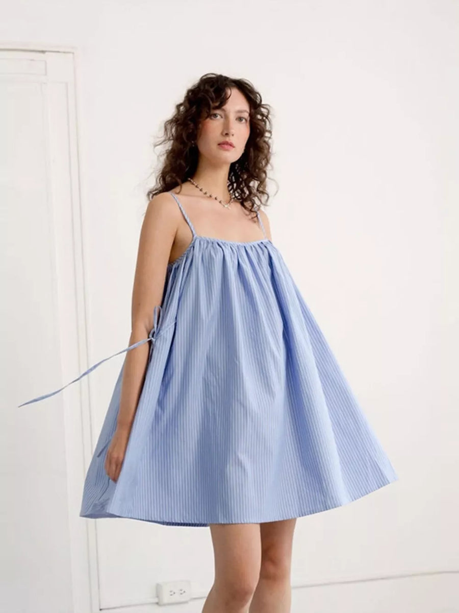 Strappy blue and white pinstripe mini dress with a gathered square neckline and tie details.