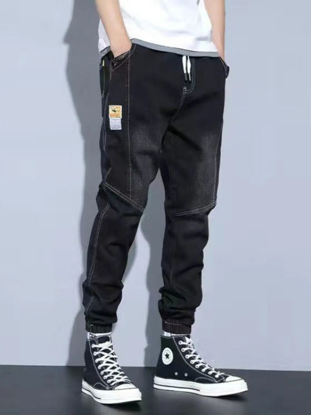 Black jogger jeans with drawstring and pockets, men's denim pants with white stitching