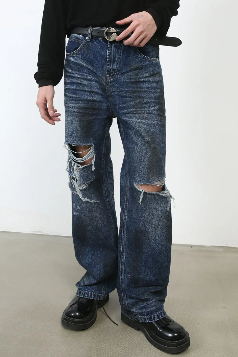 Dark wash denim jeans with distressed rips at the knees and a relaxed fit.