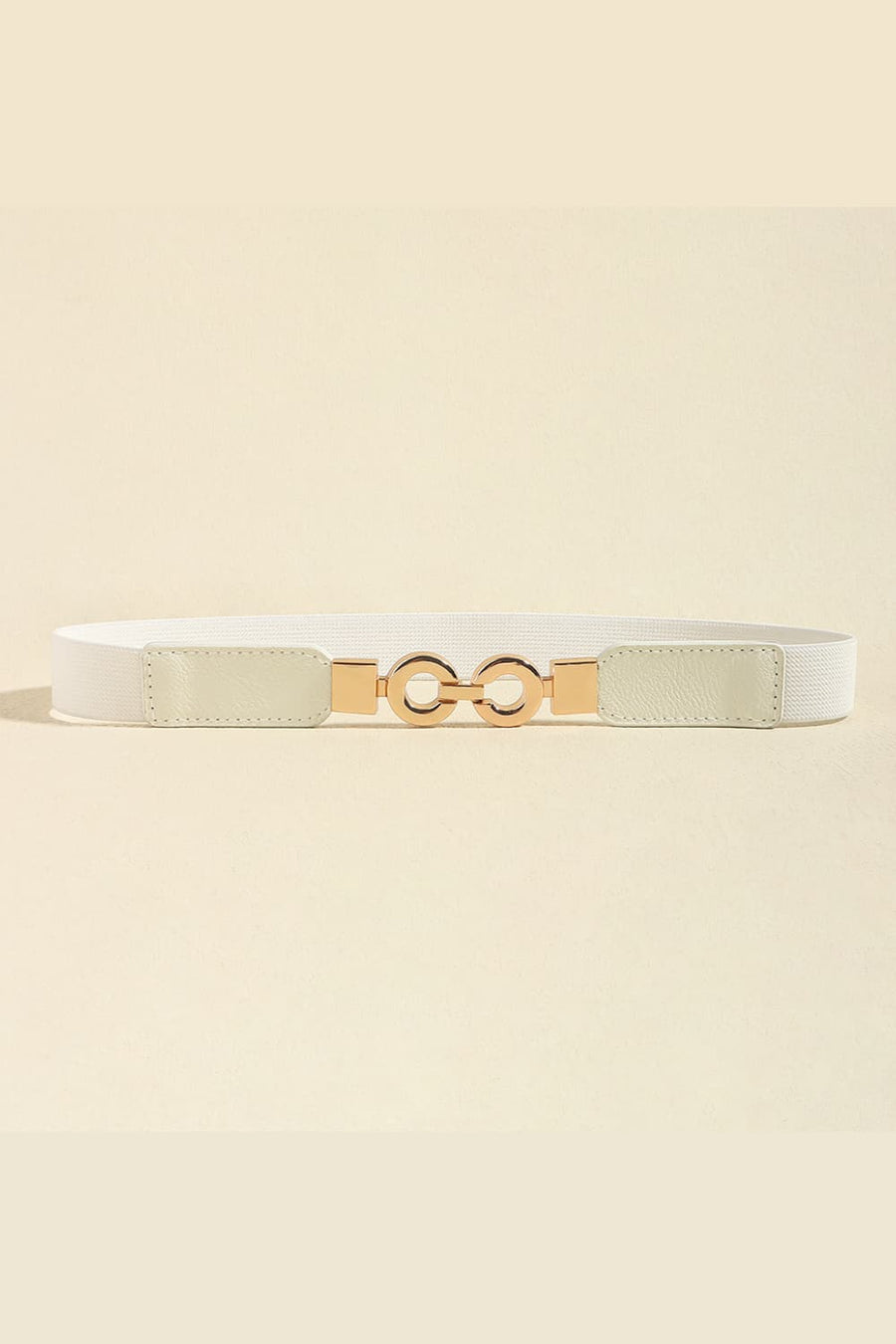 White elastic belt with gold interlocking circle buckle and faux leather ends