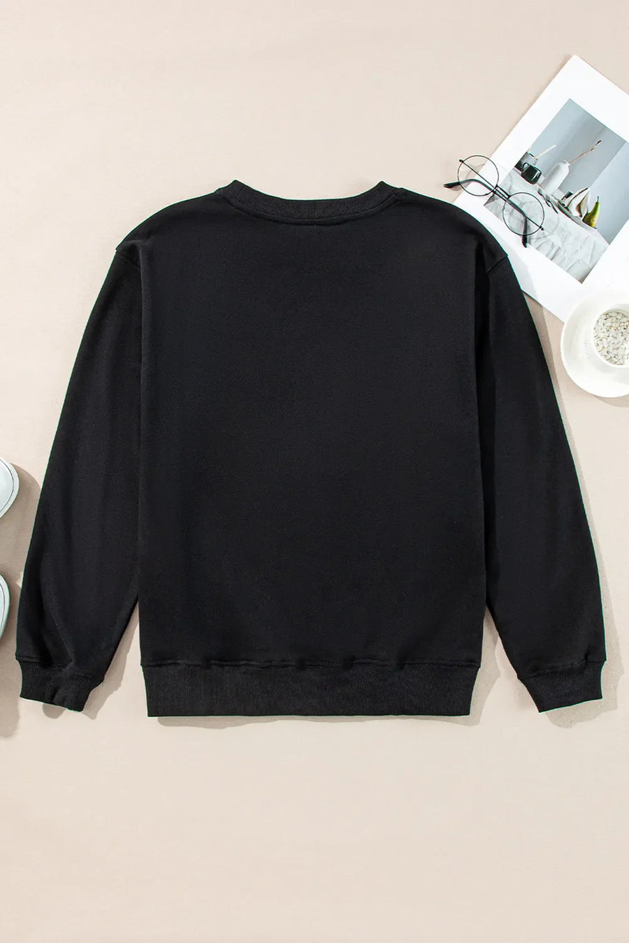 Black crewneck sweatshirt with a graphic print on the front.