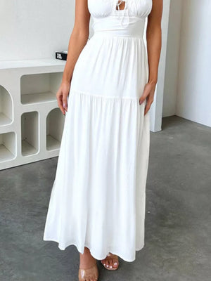 White backless maxi dress with crisscross detail and tiered skirt.
