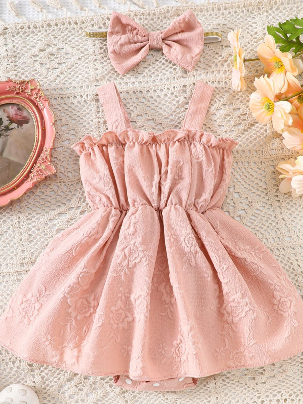 Pink floral embossed baby one-piece with ruffles and matching headband