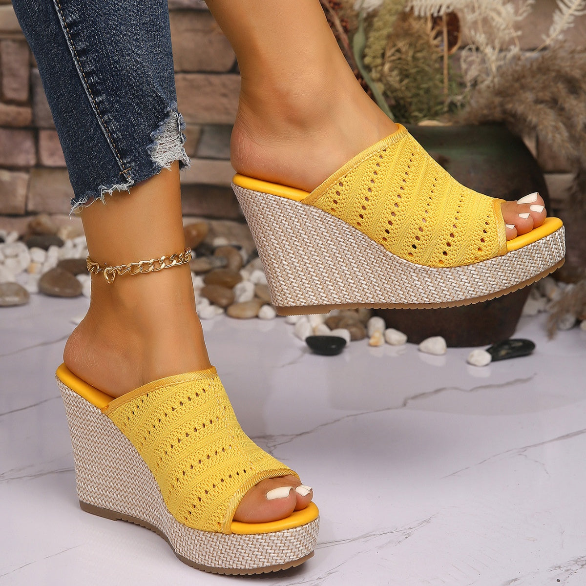 Yellow perforated espadrille wedge sandals with open toe and woven wedge heel.