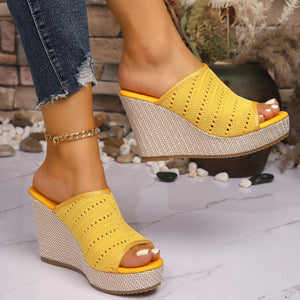 Yellow perforated espadrille wedge sandals with open toe and woven wedge heel.