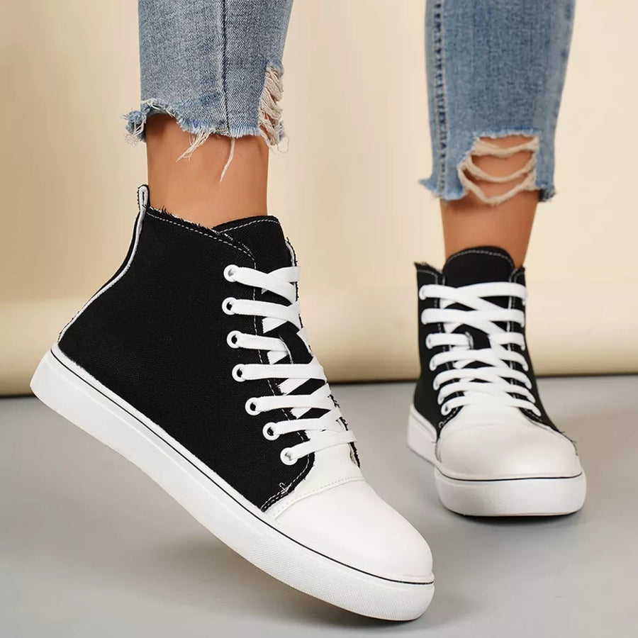 Black and white canvas high-top sneakers with white laces and soles.
