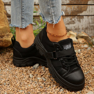 Black lace up platform sneakers with buckle strap detail and chunky sole.