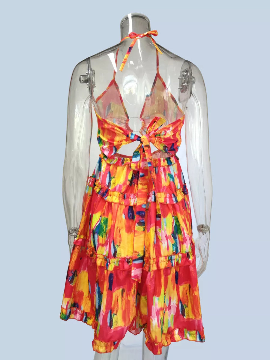 Abstract print halter mini dress with cutout back and tiered ruffles.