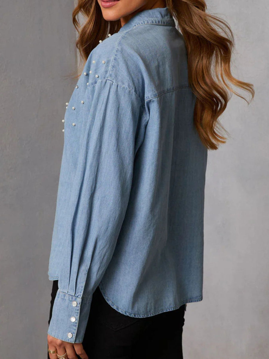 Light blue denim button-up shirt with pearl embellishments on shoulders and cuffs.