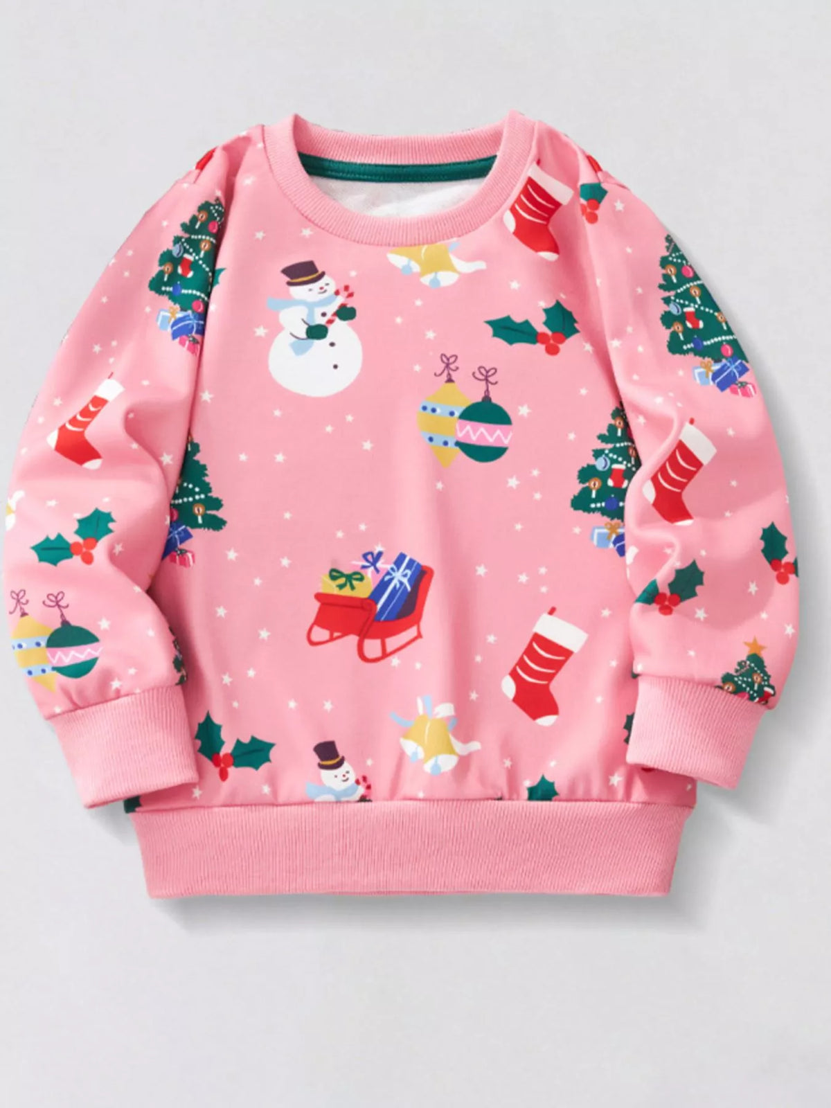 Pink crew neck sweatshirt with allover Christmas print featuring snowmen, trees, and stockings.