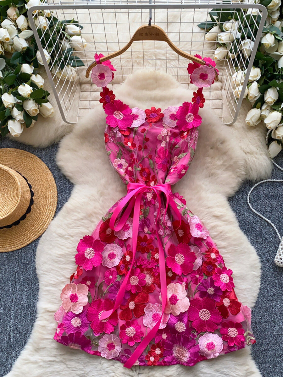 Embroidered floral mini dress in pink with applique flowers and a ribbon bow detail.