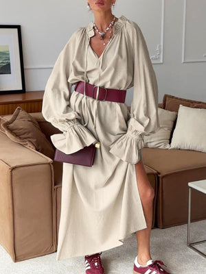 Beige cotton maxi dress with tie neck, ruffled cuffs, and side slit.