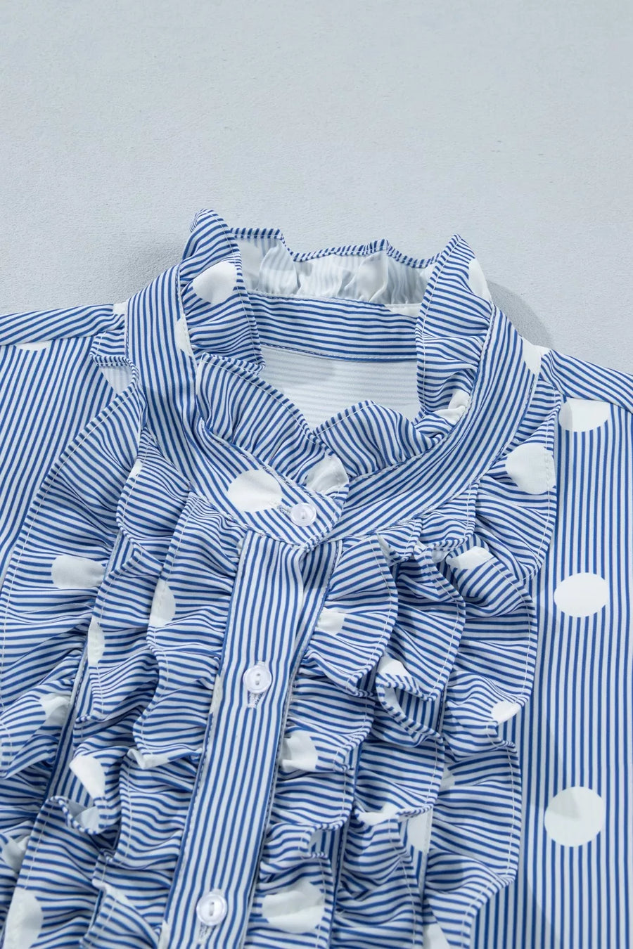 Blue and white striped button-down shirt with polka dots and ruffles.