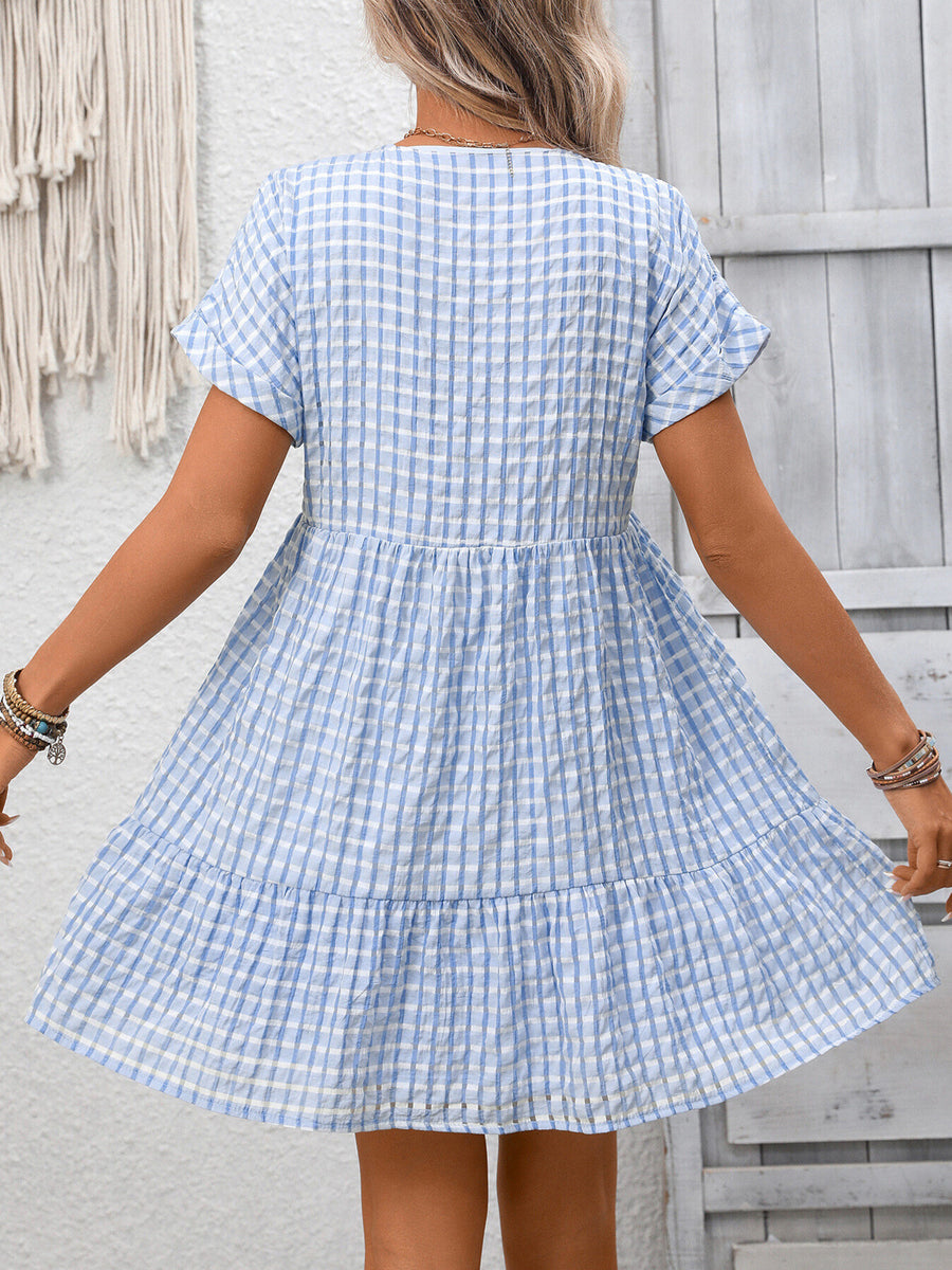 Light blue plaid V-neck mini dress with short sleeves and tiered skirt.