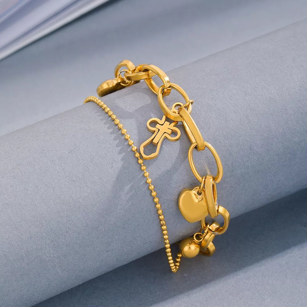 Gold charm bracelet with cross and heart charms