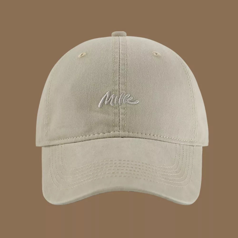 Beige baseball cap with embroidered "Milk" text detail