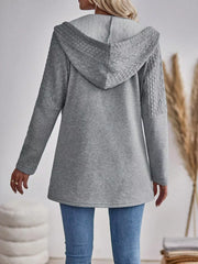 Grey cable-knit hooded zip jacket with textured sleeves and hood detail.