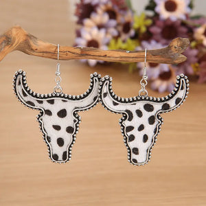Cow print bull head drop earrings with beaded silver-tone trim.