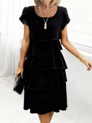 Black tiered petal sleeve dress with ruffled layers and a round neckline.