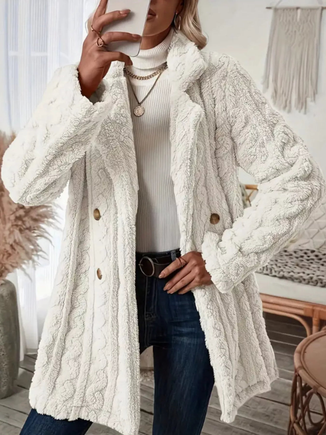 White faux shearling double-breasted overcoat with cable knit texture and button closure.