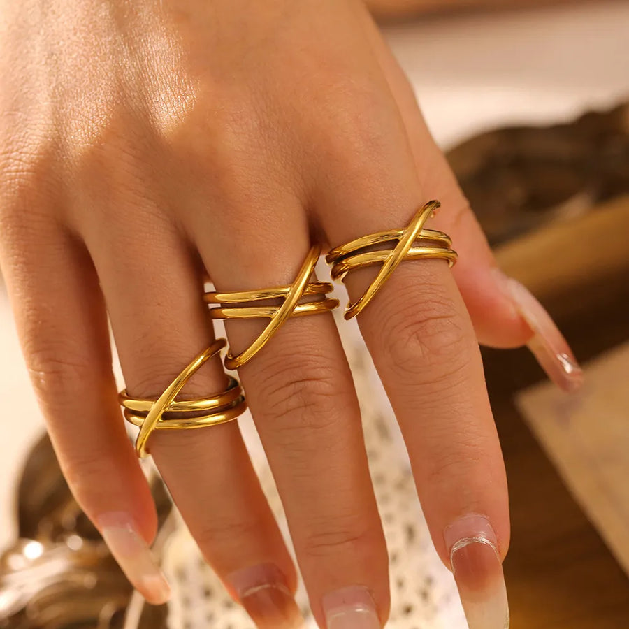 Gold intersecting band ring set with three stacked rings on fingers.