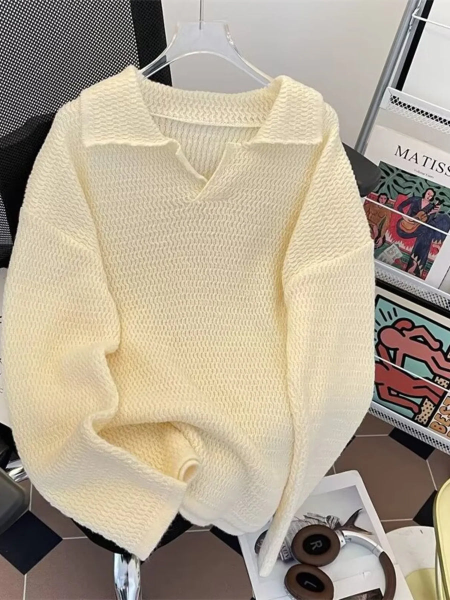 Apricot textured knit polo collar sweater with V-neck and long sleeves.