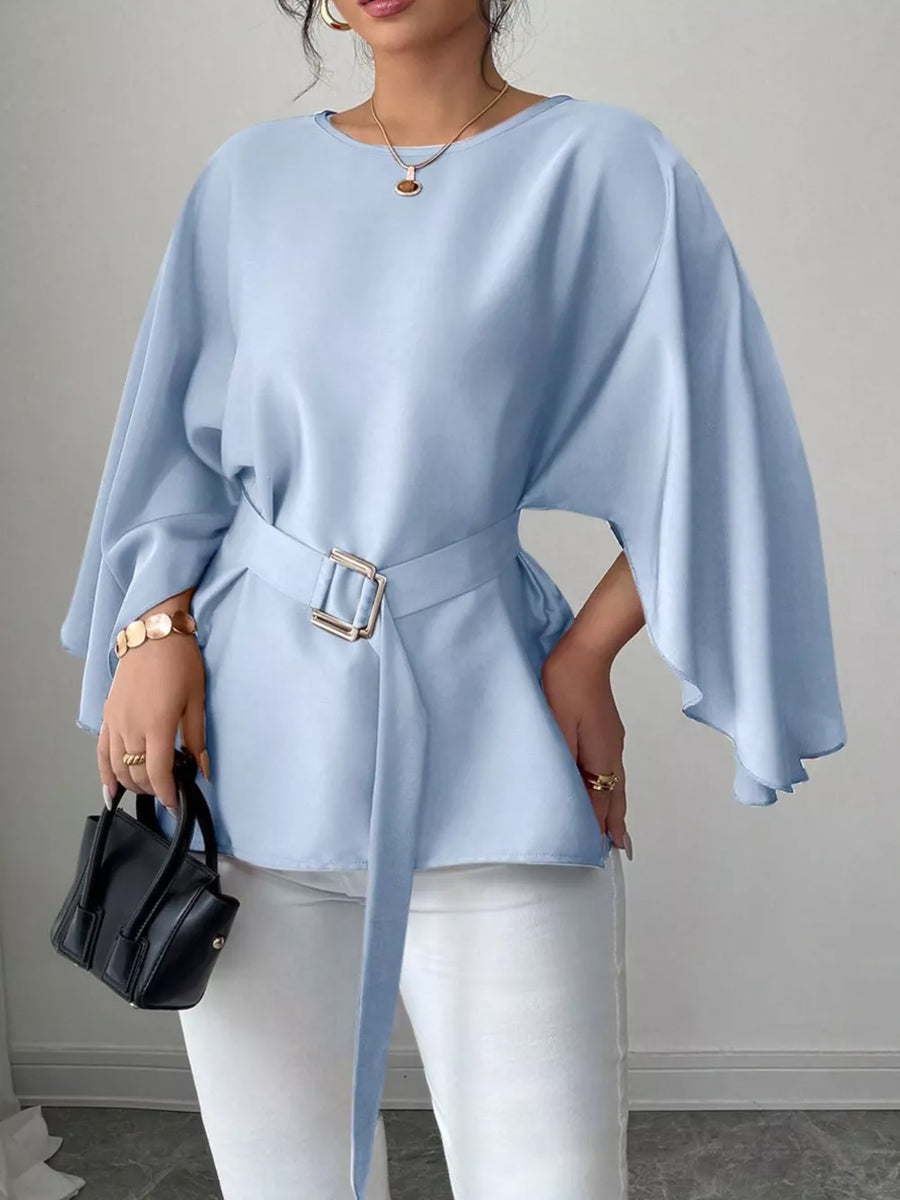 Light blue belted blouse with batwing sleeves and gold buckle detail.